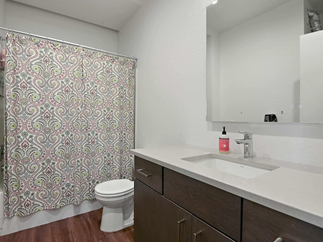 bathroom featuring shower / bathtub combination with curtain, vanity, toilet, and wood finished floors