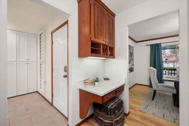 kitchen with brown cabinets, open shelves, built in desk, and baseboards