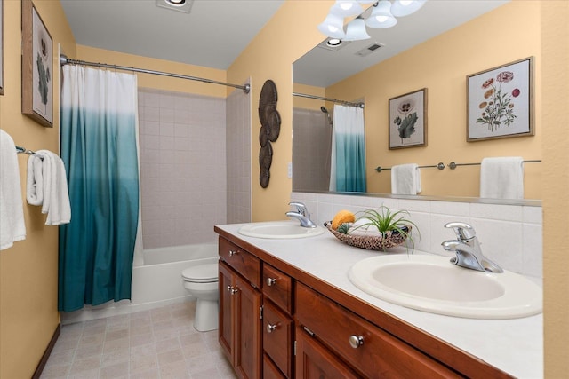 bathroom with toilet, double vanity, a sink, and visible vents