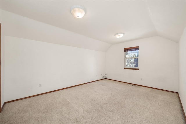 additional living space featuring lofted ceiling, baseboards, and carpet floors