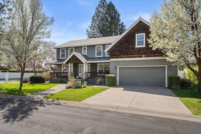 craftsman inspired home with a porch, a shingled roof, a garage, a front lawn, and concrete driveway
