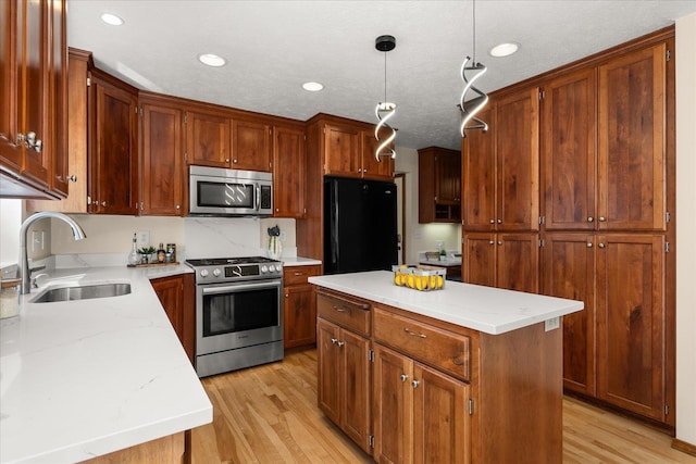 kitchen with a sink, stainless steel appliances, light wood-type flooring, a center island, and decorative light fixtures