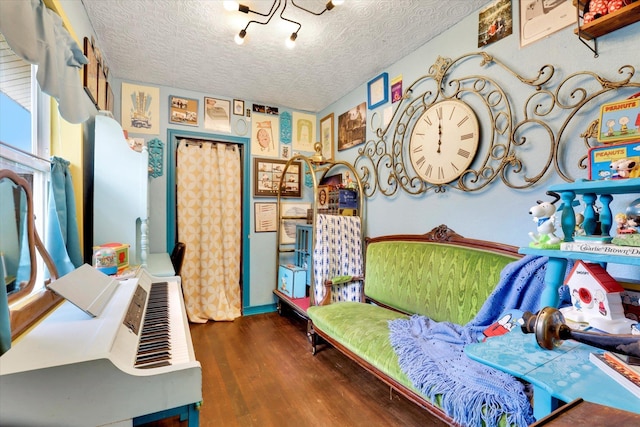 bedroom with a textured ceiling and wood finished floors