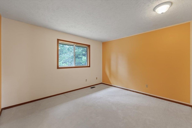 unfurnished room featuring a textured ceiling, visible vents, and carpet