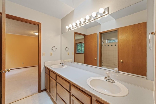 bathroom with washtub / shower combination, double vanity, baseboards, and a sink