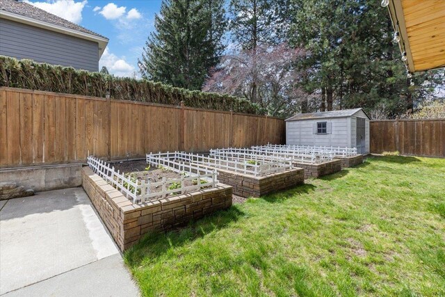 view of yard featuring a garden, an outbuilding, a fenced backyard, and a shed