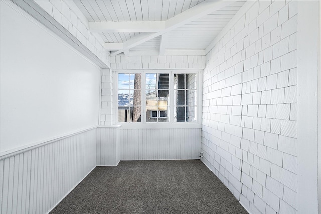 unfurnished sunroom featuring beamed ceiling