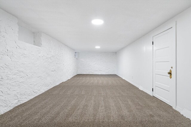 carpeted empty room with a textured wall