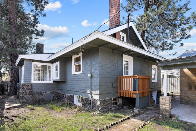 view of property exterior with a patio and a chimney