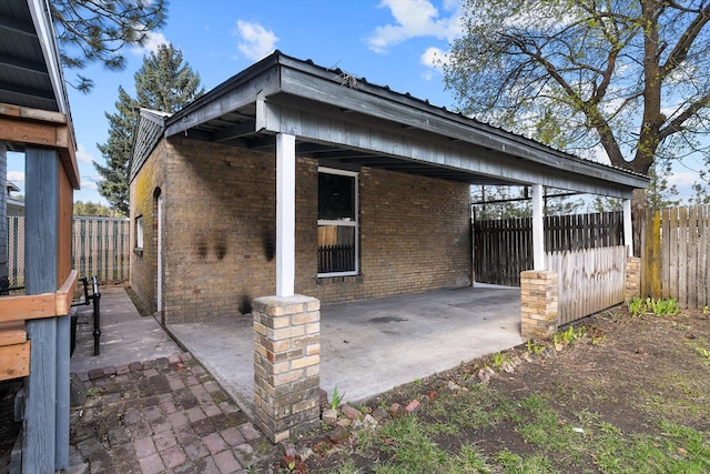 exterior space with a patio area, brick siding, and fence