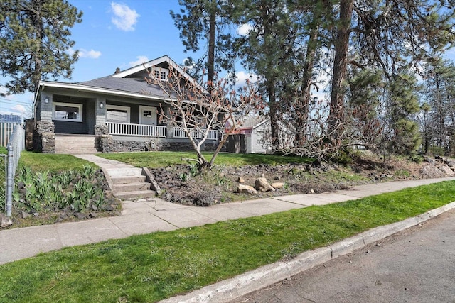 view of front of home with covered porch and a front lawn