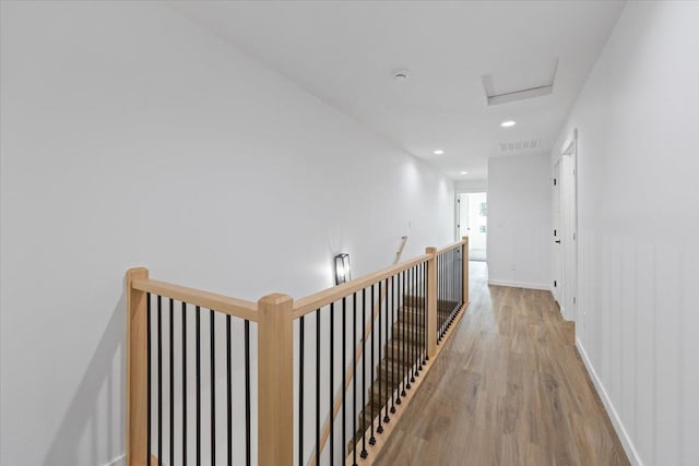 hall with attic access, visible vents, baseboards, light wood-style floors, and recessed lighting