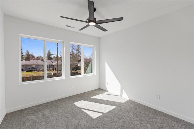 spare room with ceiling fan, carpet flooring, baseboards, and visible vents
