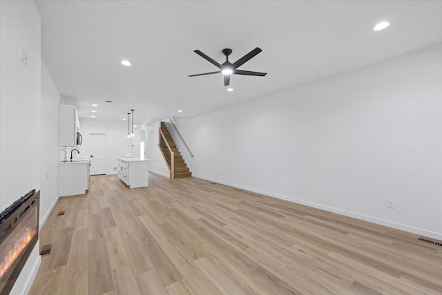 1920 E 37th Ave, Spokane, WA 99203 - unfurnished living room with stairs, visible vents, light wood-style flooring, and ceiling fan
