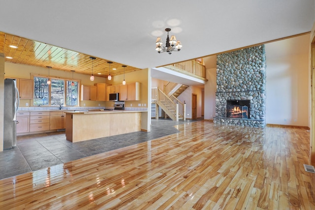 kitchen with light brown cabinets, open floor plan, light countertops, appliances with stainless steel finishes, and light wood finished floors