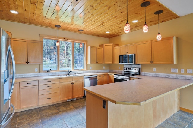 kitchen featuring a sink, light brown cabinetry, a peninsula, and stainless steel appliances