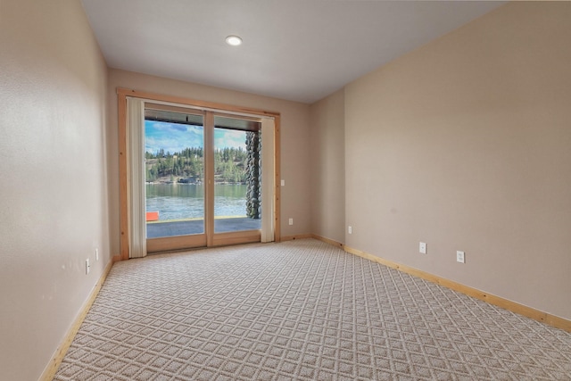 unfurnished room featuring light colored carpet and baseboards