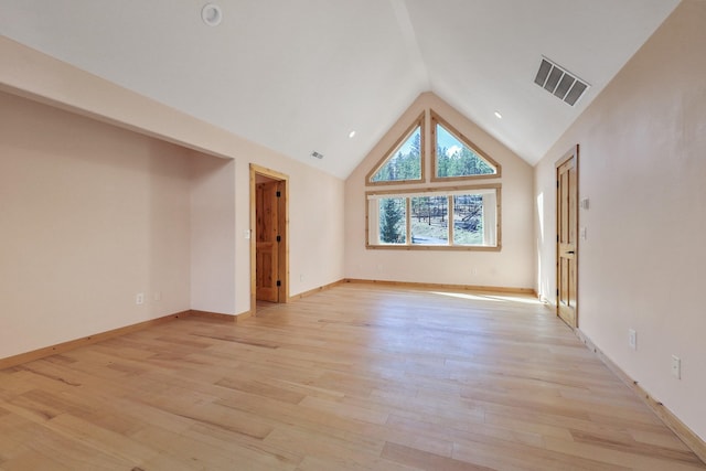 unfurnished room featuring visible vents, baseboards, high vaulted ceiling, and light wood-style floors