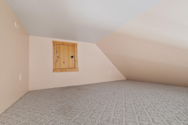 bonus room with carpet flooring and vaulted ceiling