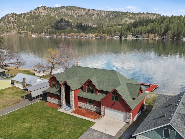 bird's eye view featuring a wooded view and a water view