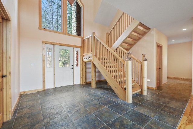 entrance foyer featuring a towering ceiling, recessed lighting, baseboards, and stairway