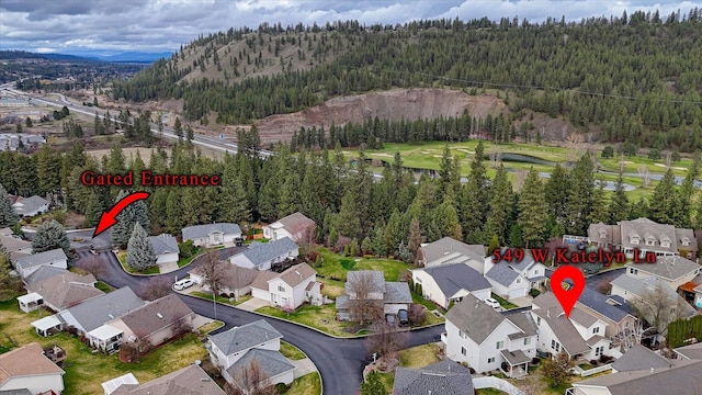 aerial view with a wooded view, a mountain view, and a residential view