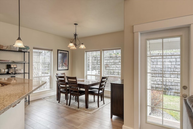 dining room with light wood finished floors, baseboards, and a wealth of natural light