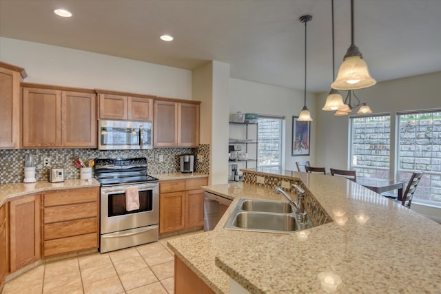 kitchen featuring light tile patterned floors, tasteful backsplash, appliances with stainless steel finishes, a healthy amount of sunlight, and a sink