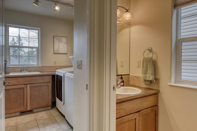 bathroom with a sink, tile patterned flooring, two vanities, and separate washer and dryer