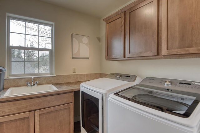laundry room featuring independent washer and dryer, a sink, and cabinet space
