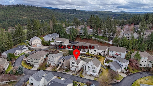 drone / aerial view with a wooded view and a residential view