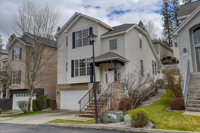 traditional-style home with an attached garage, stairway, cooling unit, concrete driveway, and roof with shingles