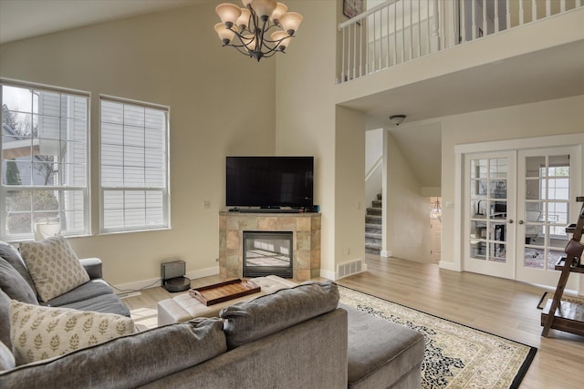 living area with french doors, wood finished floors, visible vents, and stairs