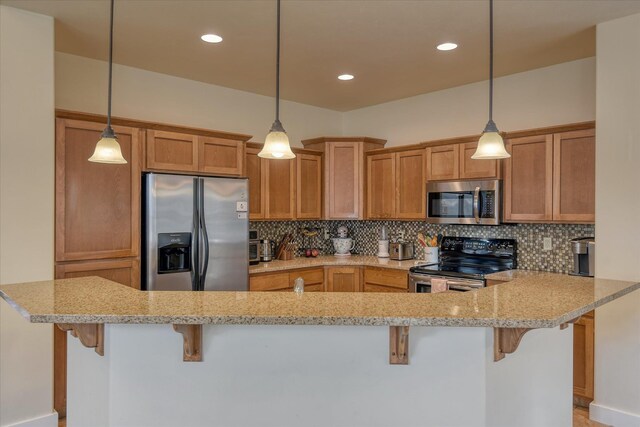 kitchen with stainless steel appliances, a breakfast bar area, and backsplash