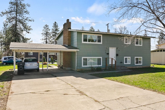 raised ranch with a carport, a chimney, driveway, and a front yard
