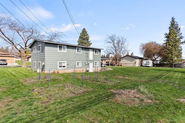rear view of property featuring a lawn