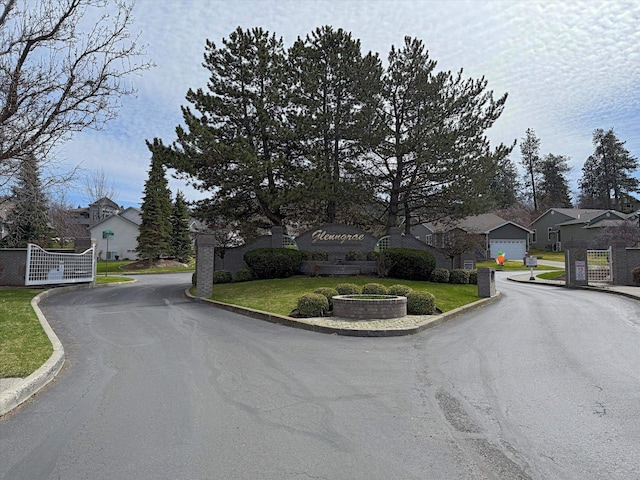 4420 E 51st Ln, Spokane, WA 99223 - view of asphalt road featuring a residential view, curbs, a gate, and a gated entry