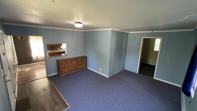 unfurnished bedroom with baseboards, ornamental molding, and dark wood-type flooring