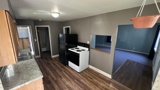 kitchen with electric range oven, freestanding refrigerator, and baseboards