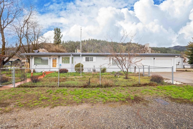 ranch-style home with a garage and a fenced front yard