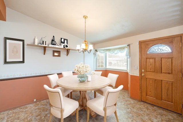 dining room with a chandelier and vaulted ceiling