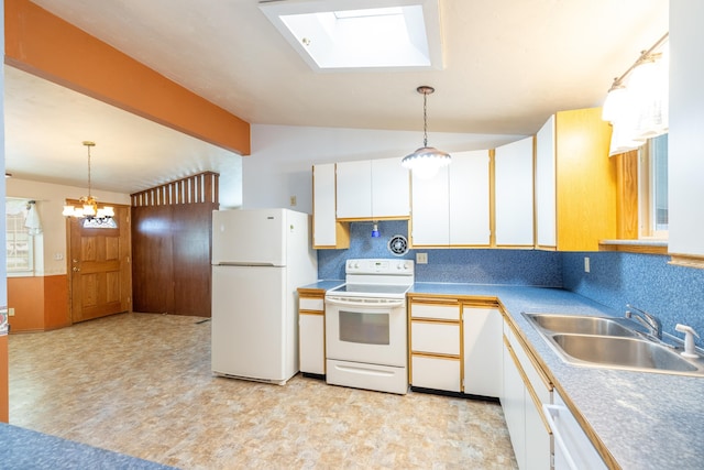 kitchen with white appliances, vaulted ceiling with skylight, white cabinets, light floors, and a sink