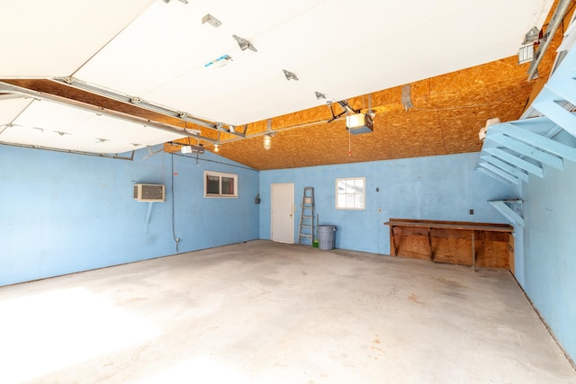 garage with a wall mounted AC and a garage door opener