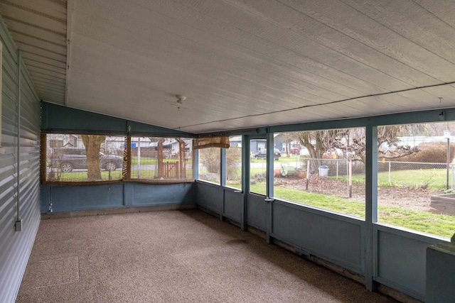 unfurnished sunroom featuring ceiling fan and plenty of natural light