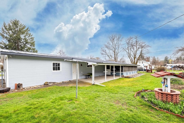 rear view of house featuring a patio and a yard