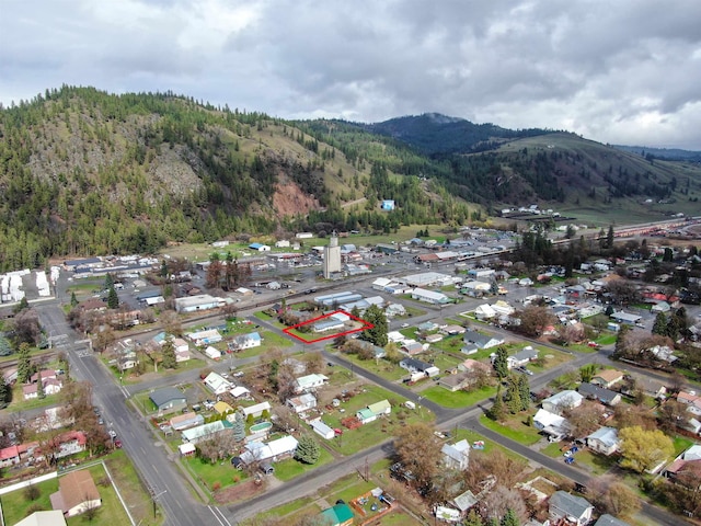 aerial view featuring a wooded view and a mountain view