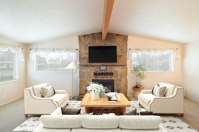 carpeted living area with a stone fireplace and vaulted ceiling with beams
