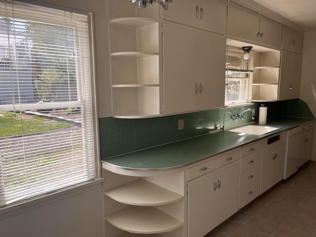 kitchen with backsplash, dishwasher, open shelves, and a sink