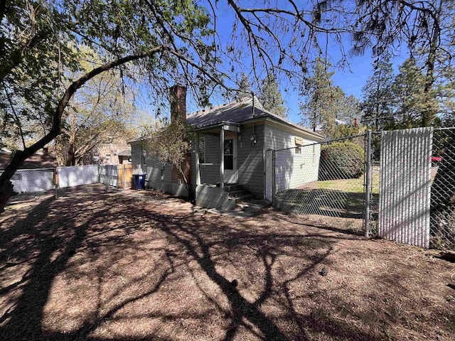 exterior space featuring fence, a gate, and a chimney