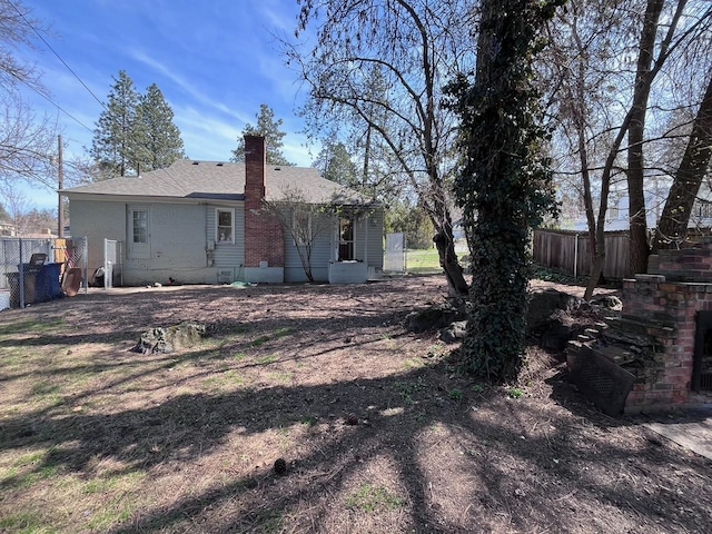 rear view of property featuring fence and a chimney